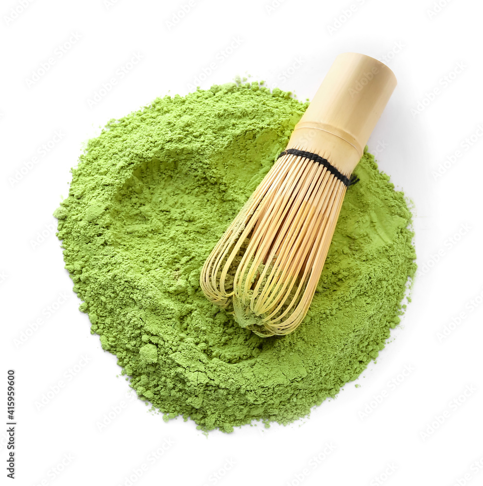 Powdered matcha tea and chasen on white background