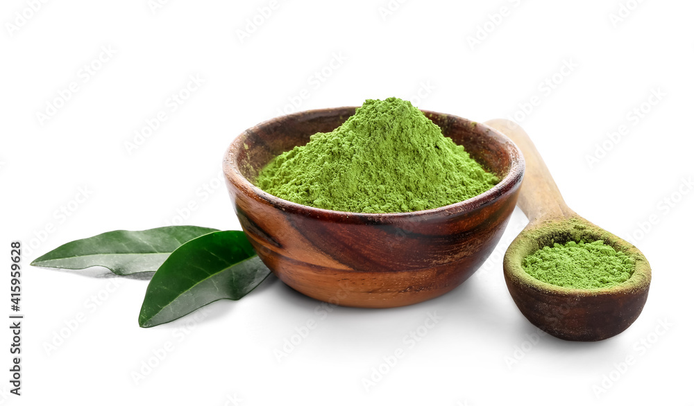 Bowl with powdered matcha tea and spoon on white background