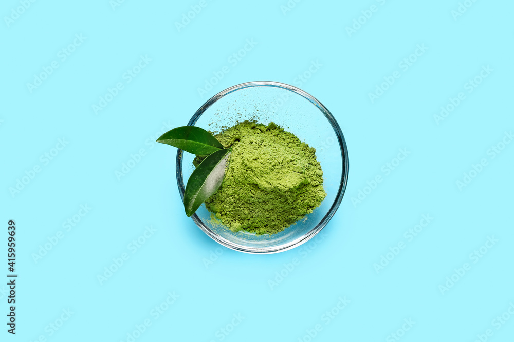 Bowl with powdered matcha tea on color background