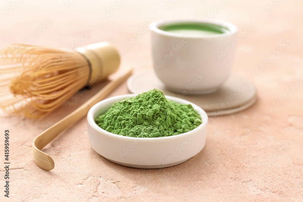 Bowl with powdered matcha tea on color background