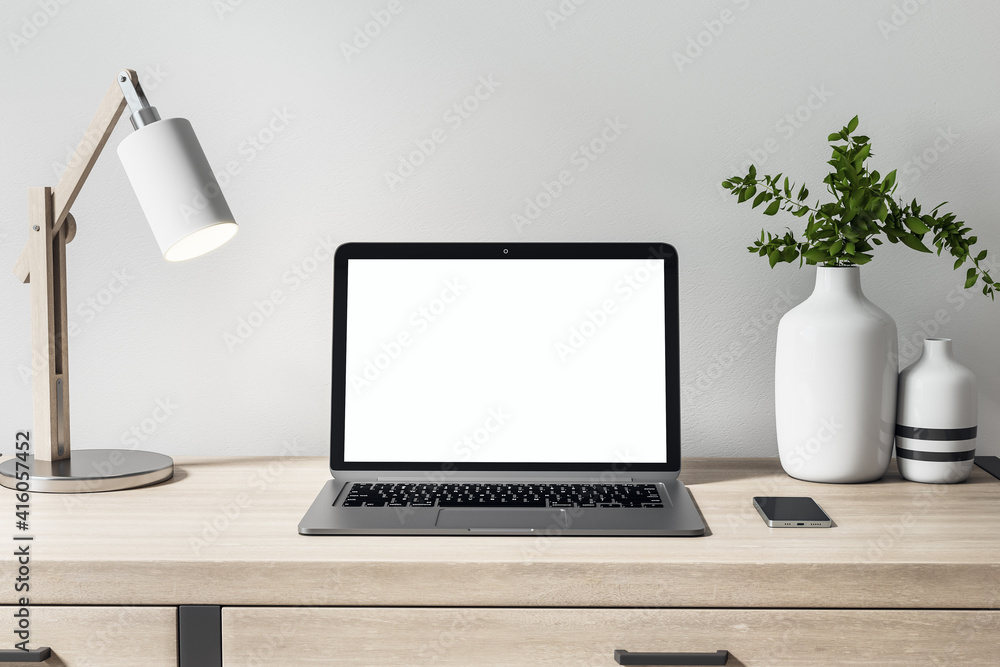 Front view on blank white laptop monitor on wooden table with decor elements for comfortable remote 