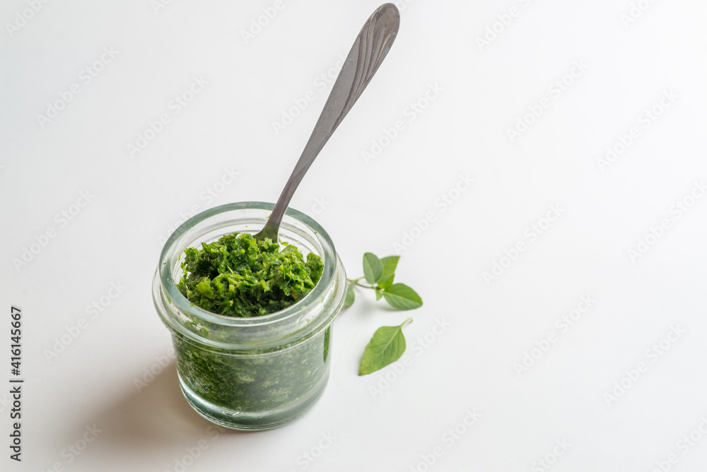 pesto sauce in a jar take a spoon. Close shot