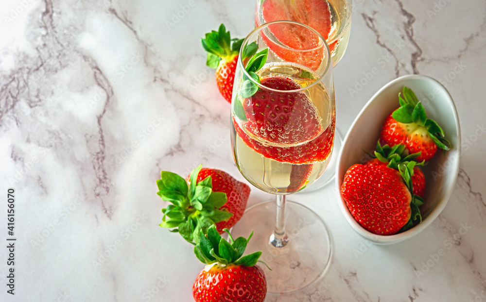 Luxury lifestyle drinking Fresh juicy strawberry in a glass of golden champagne decorated with straw