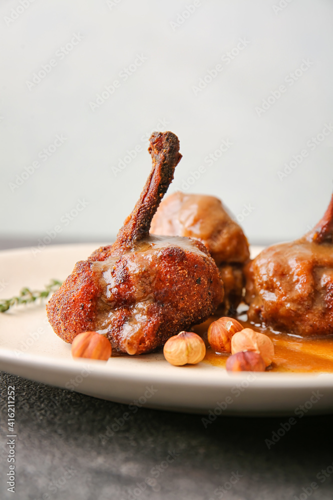 Plate with tasty chicken lollipops on dark background