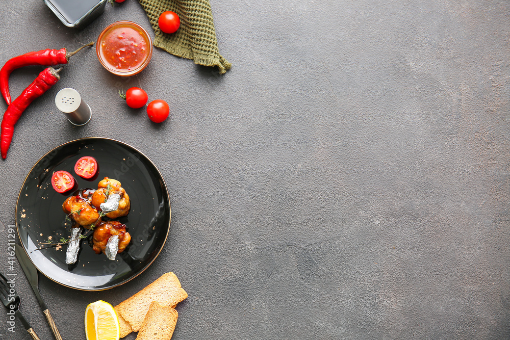 Plate with tasty chicken lollipops on dark background