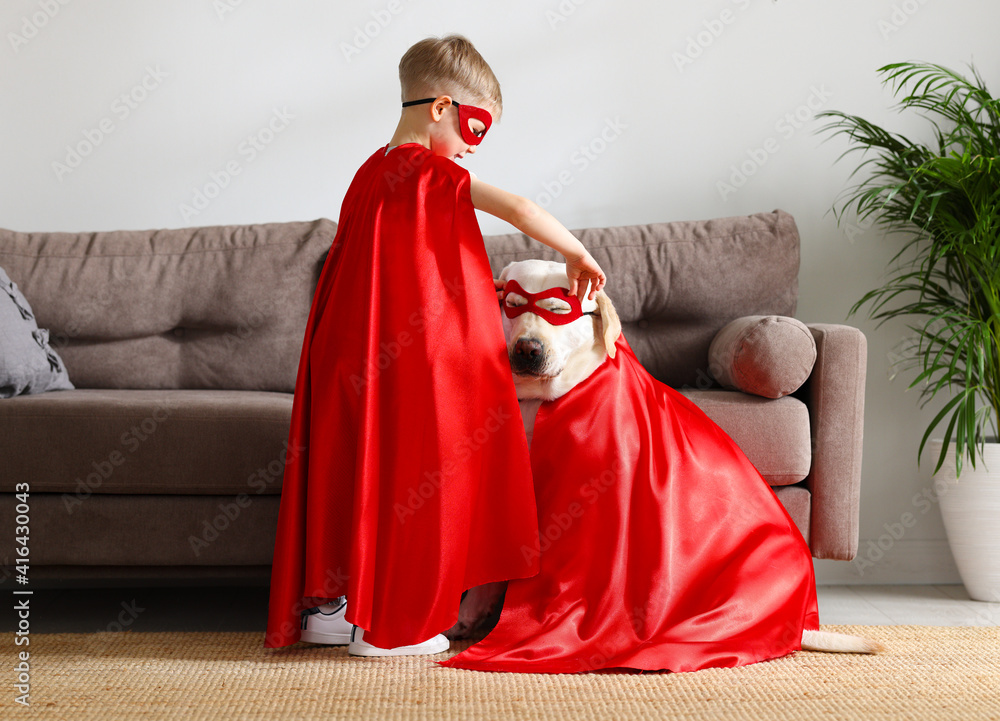 Kid with dog in Superhero costumes playing at home