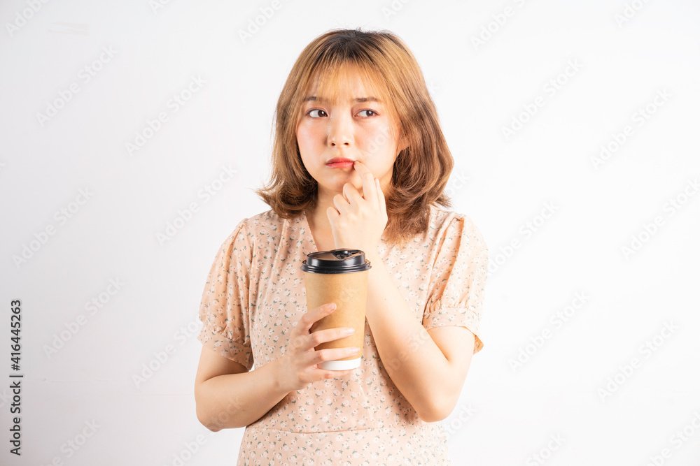 Young asian girl holding coffee cup with expression on background