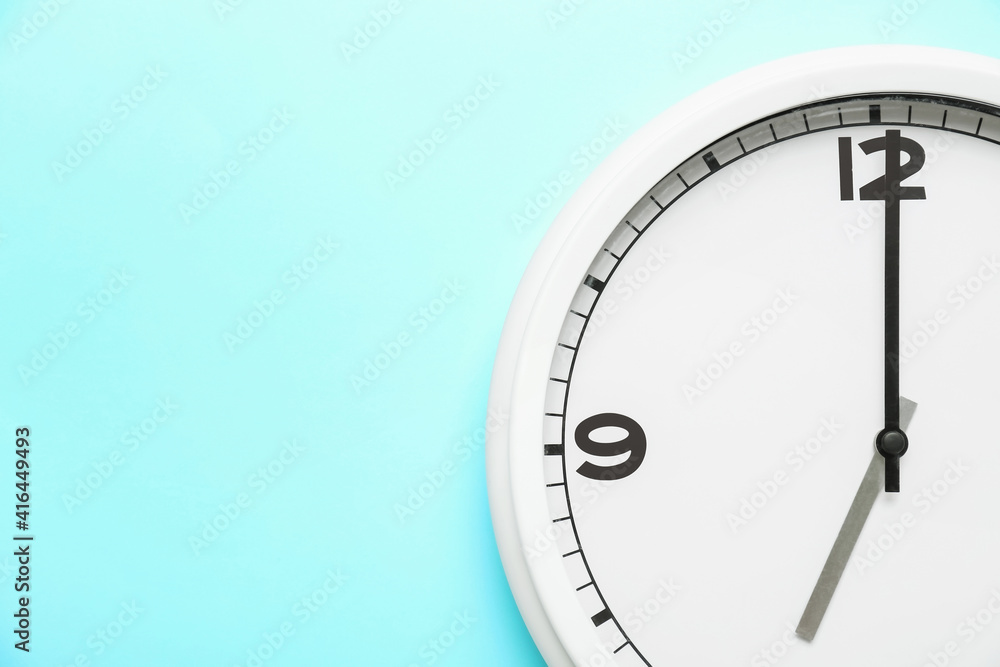 Stylish clock hanging on color wall, closeup