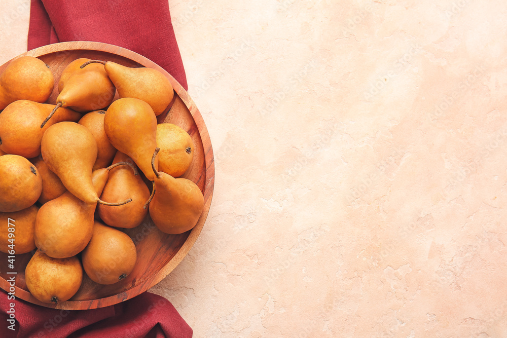 Board with fresh ripe pears on color background