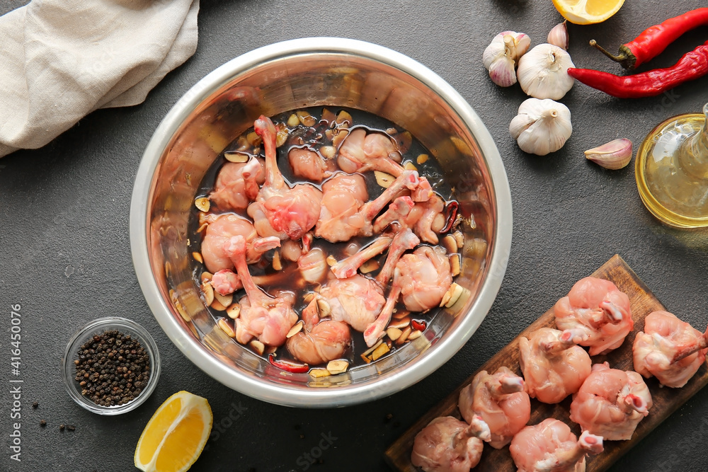 Bowl with raw chicken lollipops  on dark background