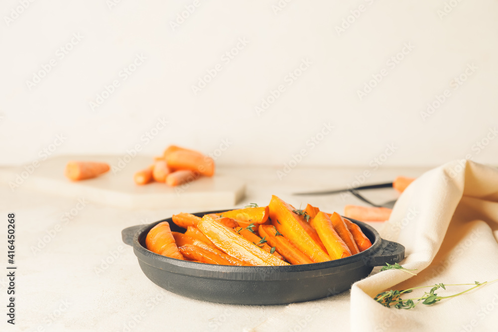 Dish of tasty baked carrot on light background