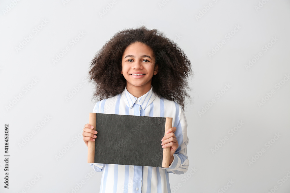 浅背景上有空白黑板的美国黑人少女