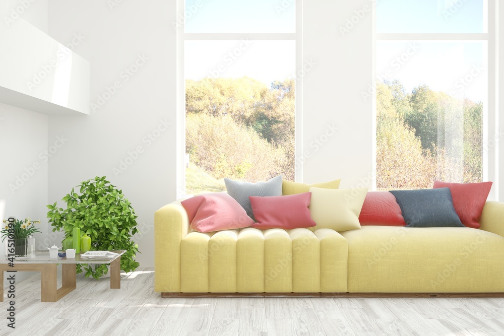 Stylish room in white color with sofa and autumn landscape in window. Scandinavian interior design. 