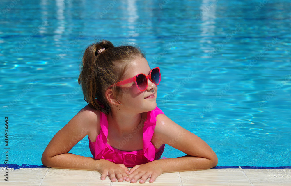 Girl relaxing at the swimming pool. Summer spa resort vacation.