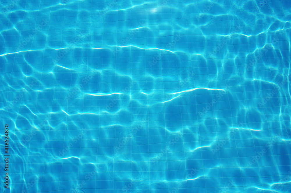 Blue water in swimming pool with sun reflection