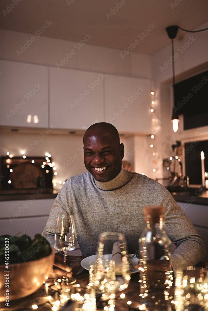 Man laughing while enjoying himself at a candlelit dinner party