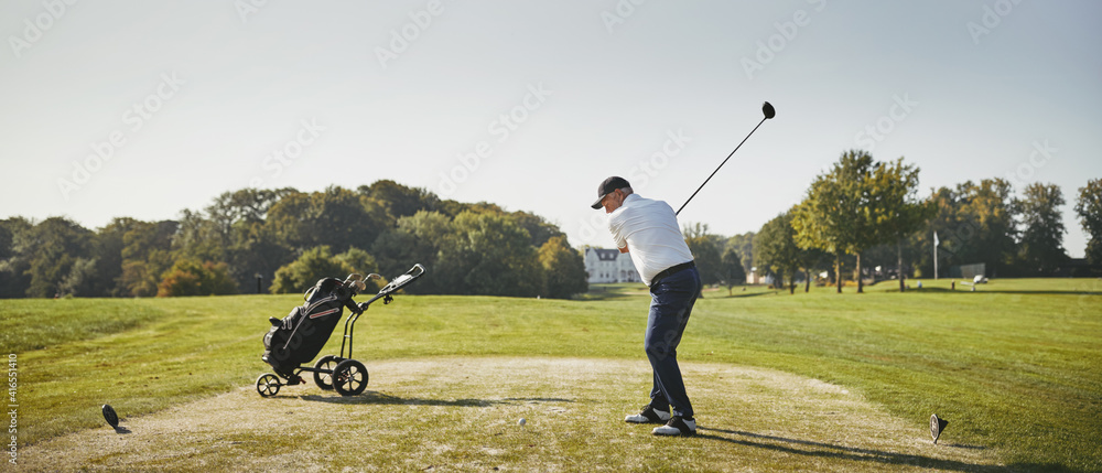 Senior man hitting his golf ball with a driver