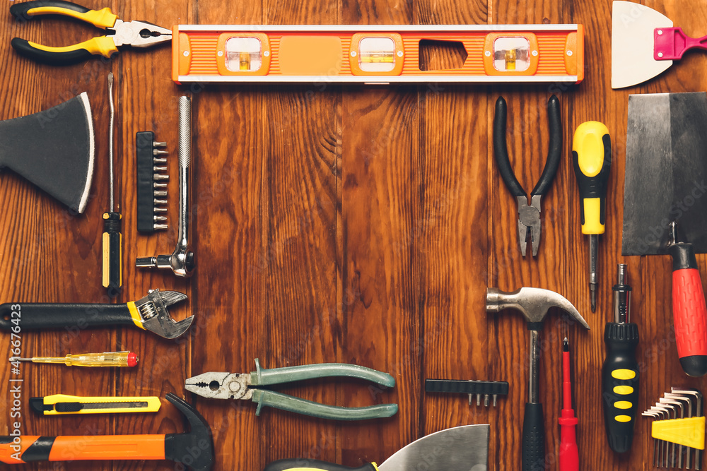 Frame made of construction tools on wooden background