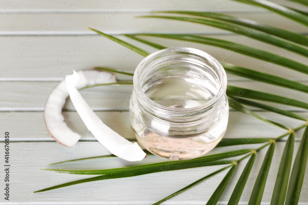 Jar of coconut oil on color wooden background