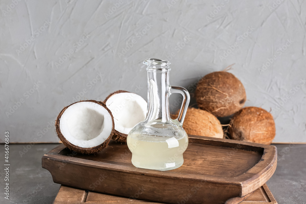 Tray with decanter of coconut oil on dark background