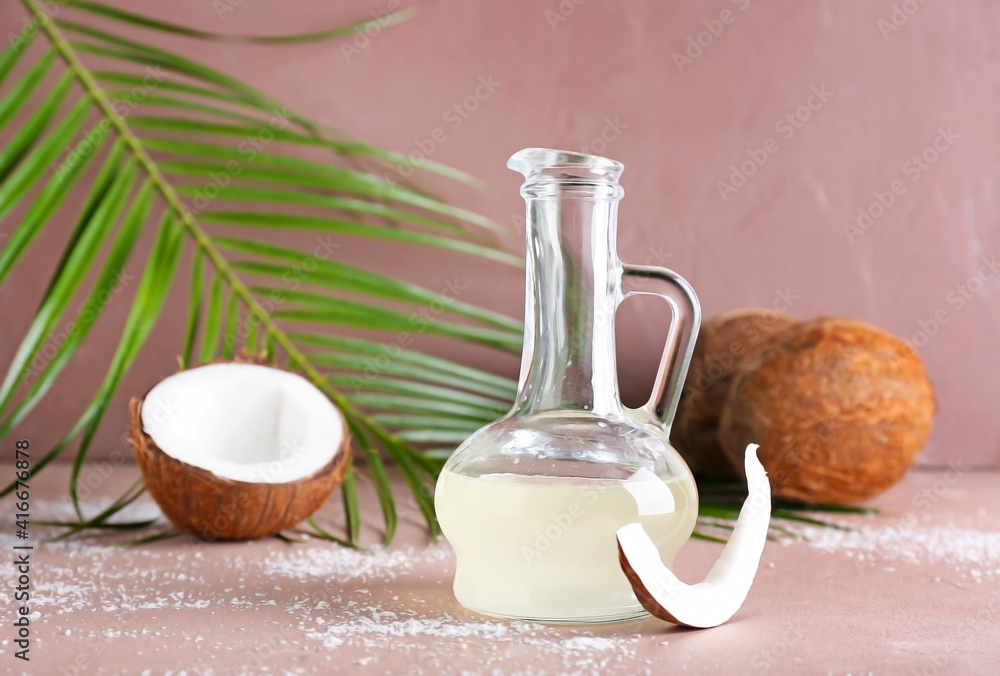 Decanter of coconut oil on color background