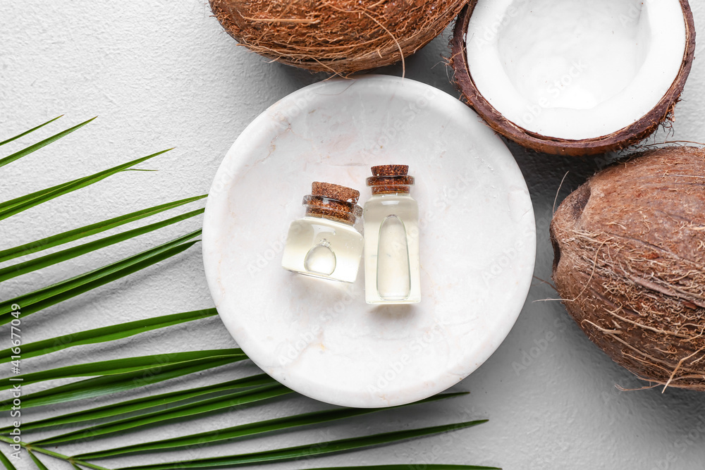 Composition with bottles of coconut oil on light background