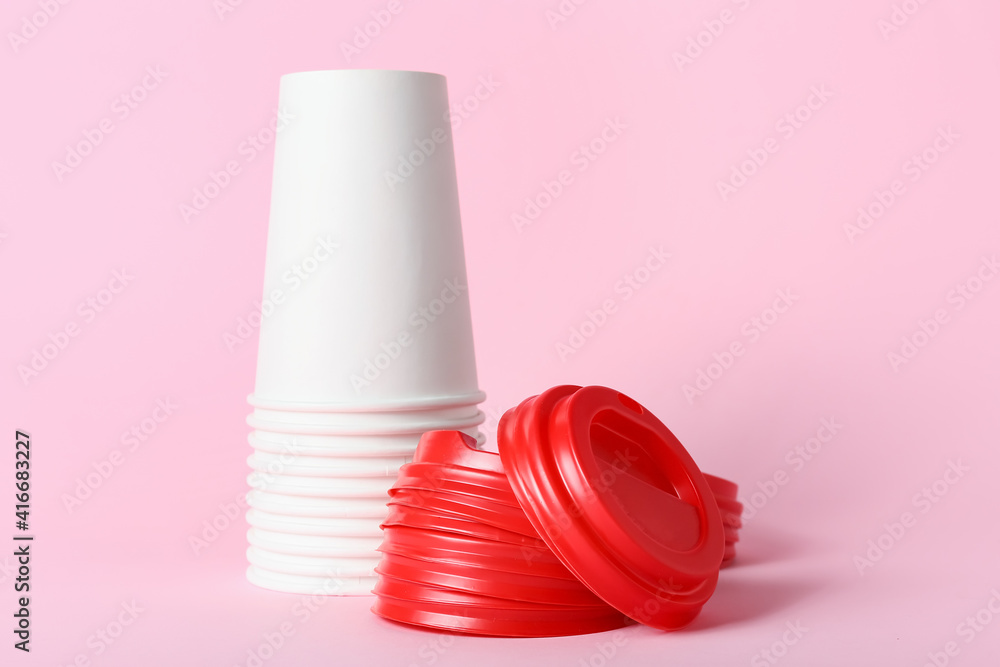 Blank takeaway cups on color background