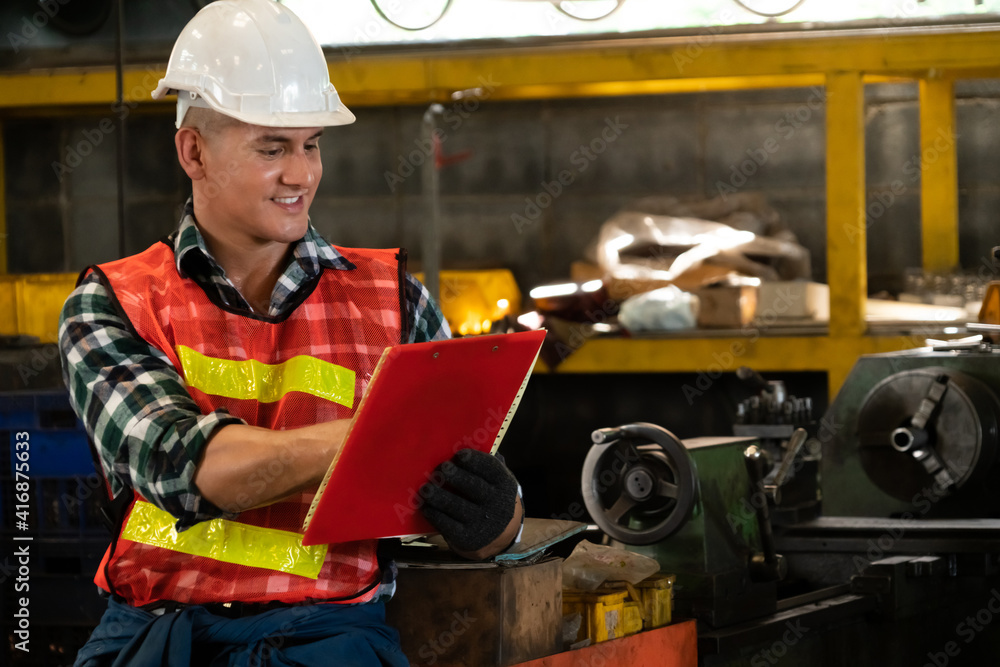 Manufacturing worker working with clipboard to do job procedure checklist . Factory production line 