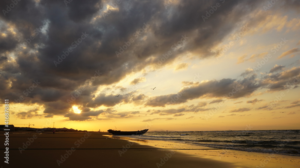 海滩上船只的轮廓。日落时的海滨景观