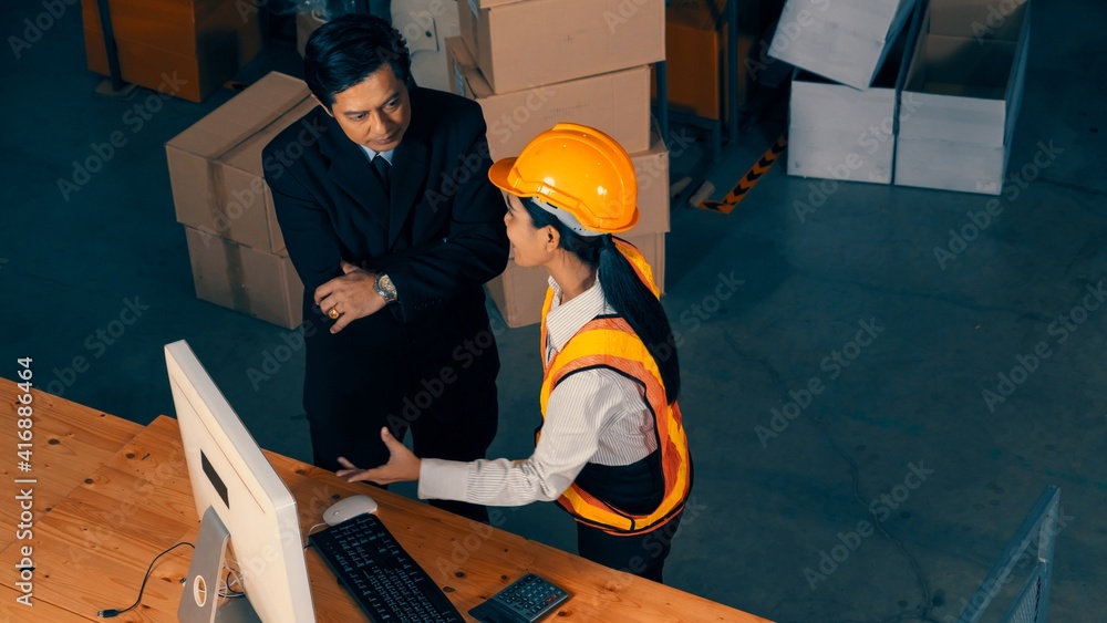 Warehouse manager and worker working in the storehouse . Logistics , supply chain and warehouse busi