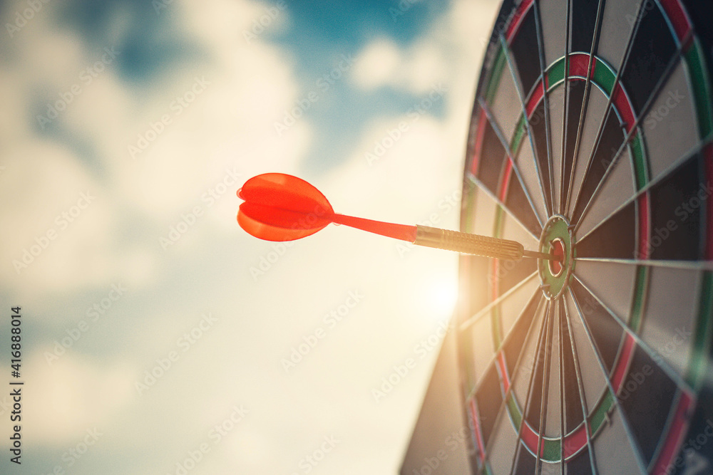 Close up shot of the dart arrow hit on bulleyes of dartboard to represent that the business reached 