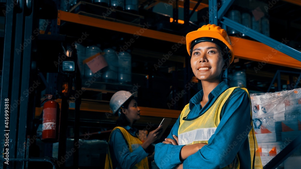 Portrait of young woman warehouse worker smiling in the storehouse . Logistics , supply chain and wa