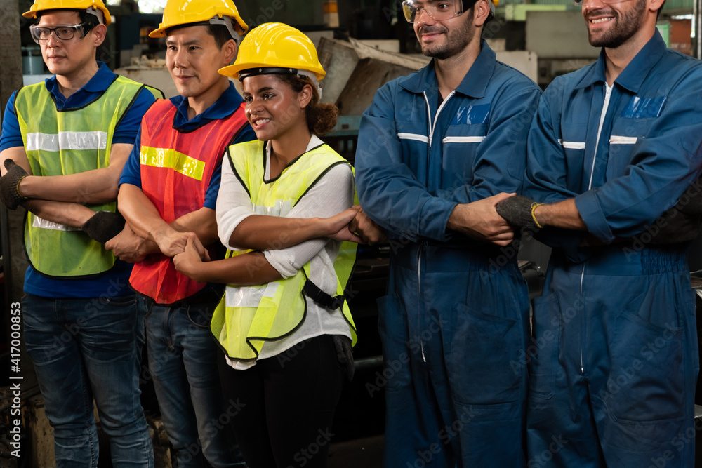 Skillful worker stand together showing teamwork in the factory . Industrial people and manufacturing