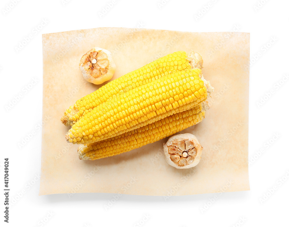 Tasty grilled corn cobs and garlic on white background