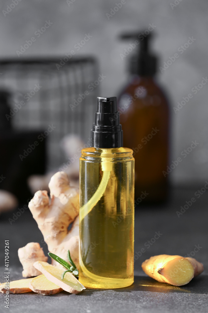 Bottle with ginger essential oil on dark background