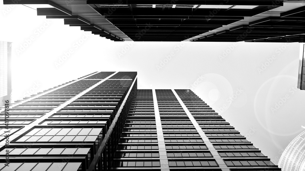 Bottom view of modern skyscrapers in business district against sky. Looking up at business buildings