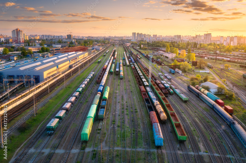 日落时货运列车的鸟瞰图。火车站、货车、铁路的俯视图。重型工业