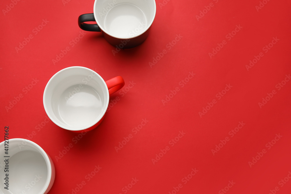 Empty cups on color background