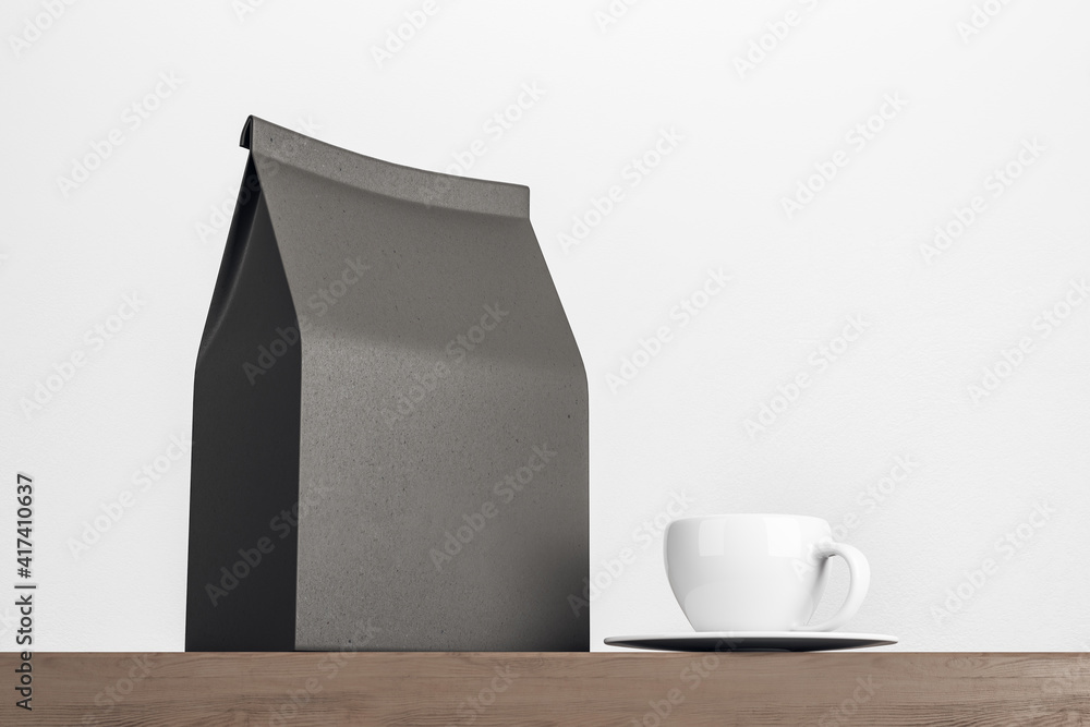 Blank black paper tea bag with white coffee mug on wooden table on white background. Mockup