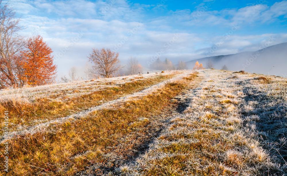 Frozen road against the backdrop of a beautiful sky and fluffy fog