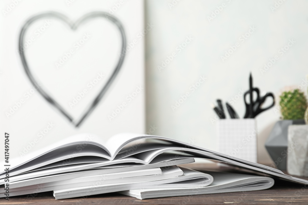 Open blank magazines on wooden table