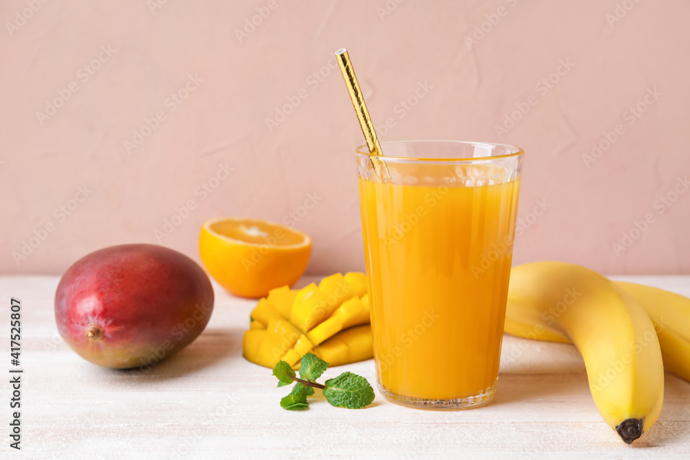 Composition with fresh juice and tropical fruits on color background