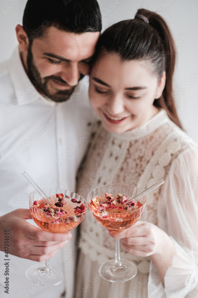 一对面带微笑的浪漫高加索夫妇带着一杯冰镇起泡香槟庆祝节日