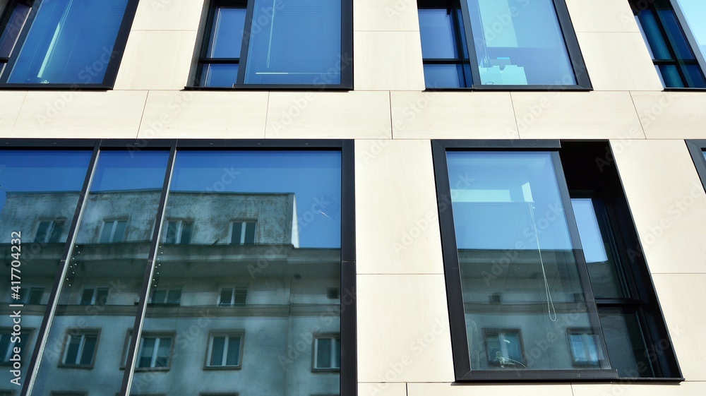 A fragment of the glass and sandstone facade of a modern office building. Wide abstract fragment of 