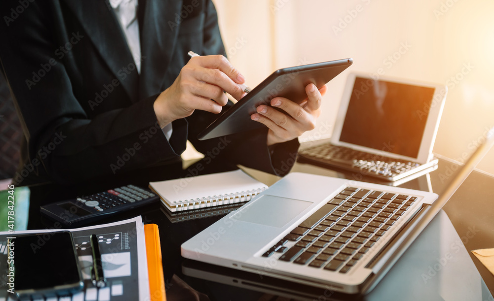 businessman using a tablet, smartphone during sunrise overlay with cityscape image.