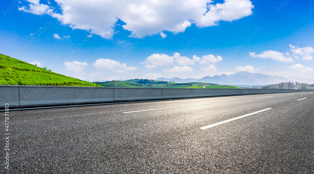 Asphalt highway and green mountain scenery.