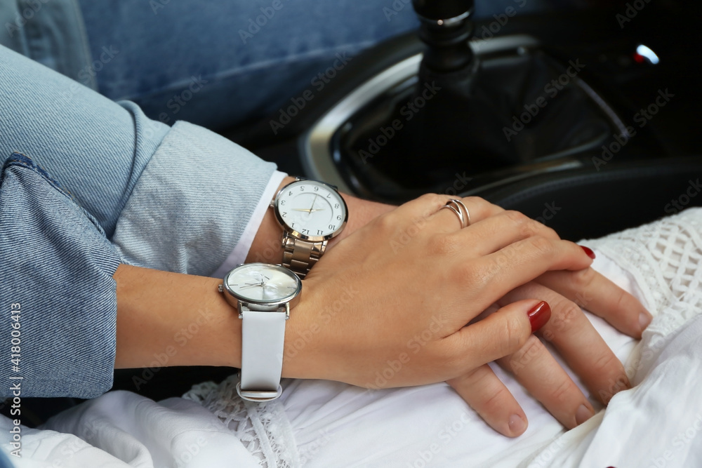 Young couple holding hands in car