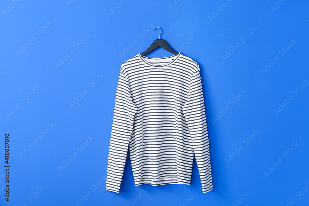 Hanger with sweatshirt on color background