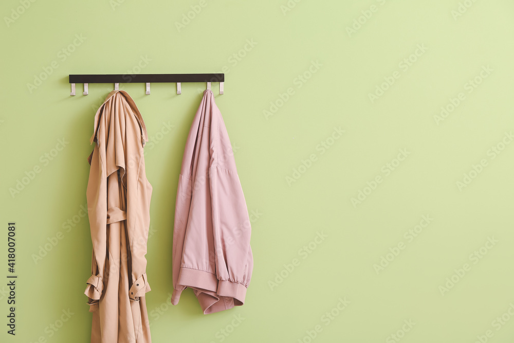 Hanger with clothes on color background