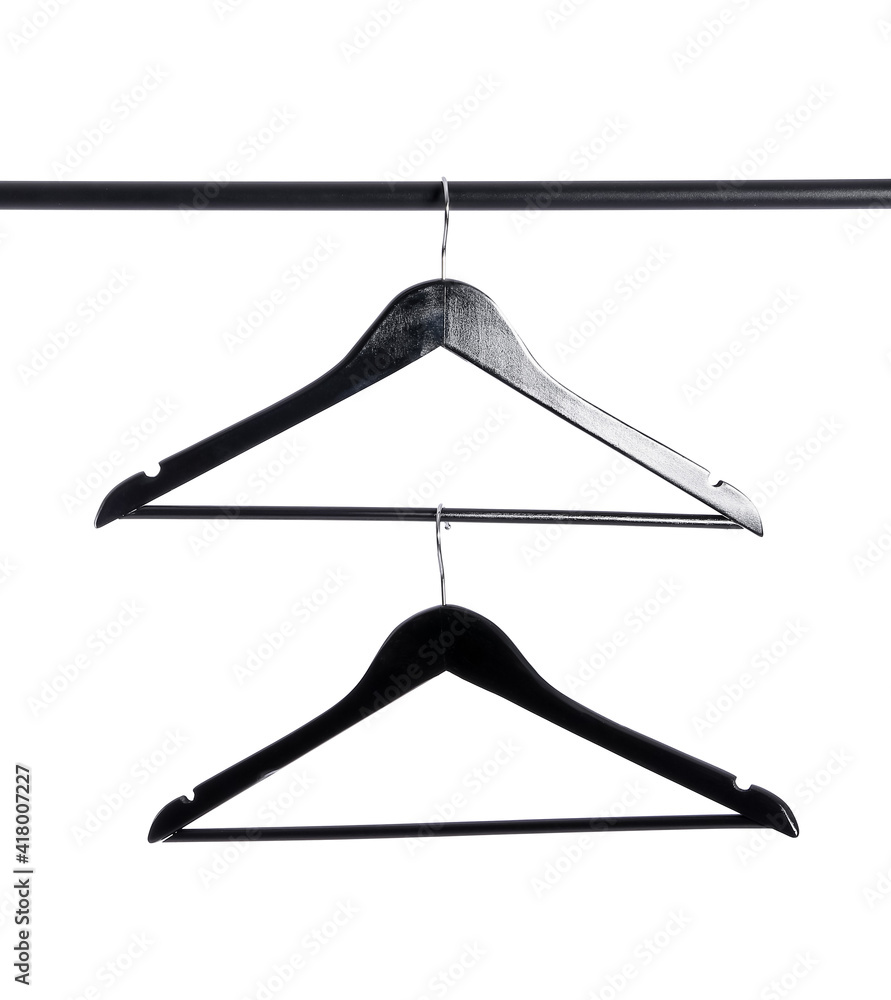 Clothes hangers on rack against white background